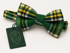 A green tartan plaid bow tie with yellow, white, and black stripes, shown with a dark green branded tag that reads Glenor Heritage.