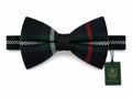 A dark green plaid bow tie with red and white stripe details, shown on a white background with a green branded hangtag attached.