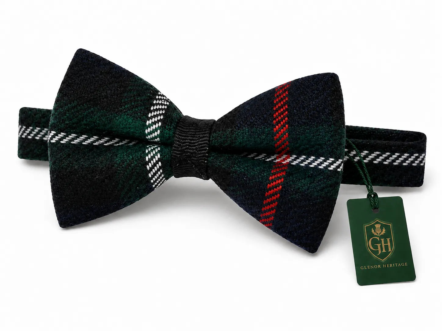 A pre-tied bow tie in a dark green and black tartan plaid pattern with red and white stripes, shown with its green branded hangtag on a white background.